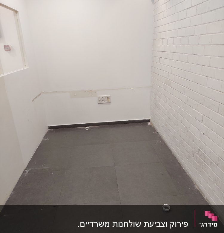 קיר לבנים לבן, רצפת אריחים, שקע חשמל